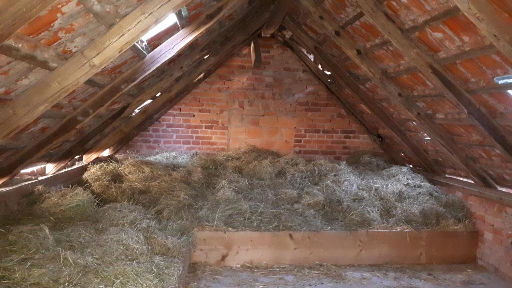 a attic with a pile of hay in it at Bett im Heu auf Bauernhof Gemeinschaftsbad Schlafsäcke in Hausbreitenbach