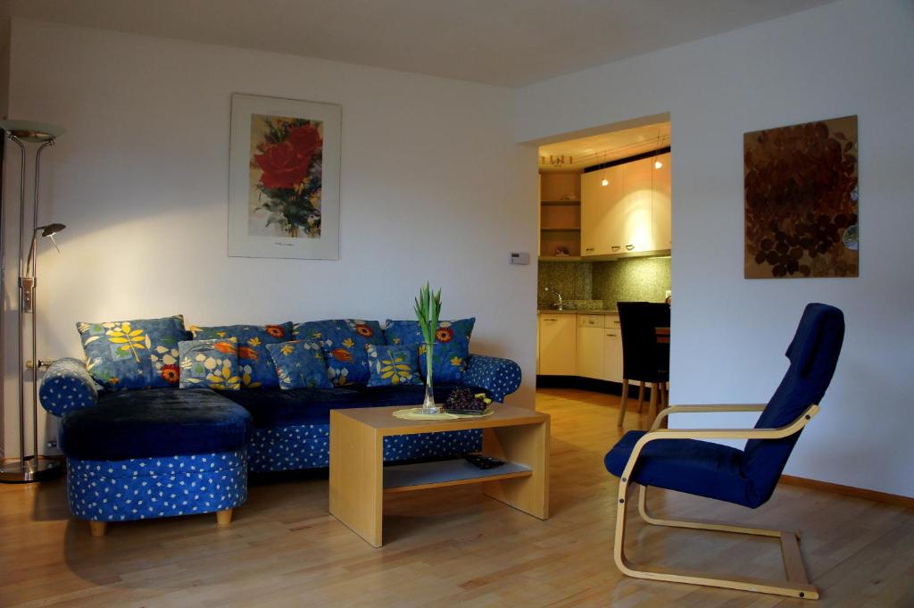 ein Wohnzimmer mit einem blauen Sofa und einem Tisch in der Unterkunft Appart Manuela in Arzl im Pitztal