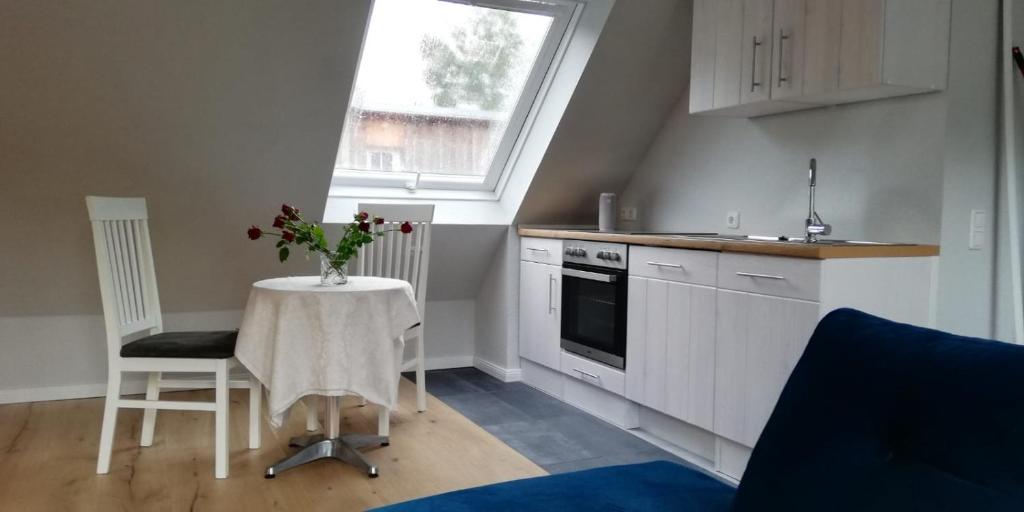 a kitchen with a table with a vase of flowers on it at Apartment bei Paulchen in Schneverdingen