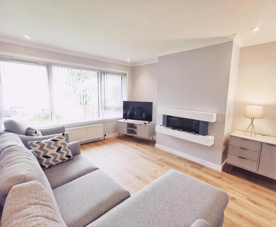 een woonkamer met een bank en een flatscreen-tv bij 21 Ivorhill in Stornoway