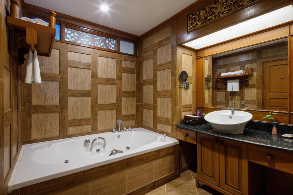 a bathroom with a tub and a sink at Khum Phaya Resort & Spa Boutique Collection in Chiang Mai