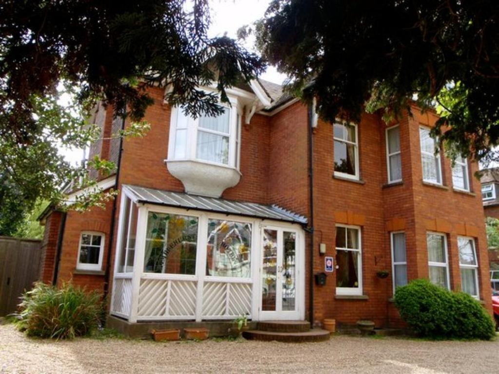 ein rotes Backsteinhaus mit einer weißen Tür in der Unterkunft Wimblehurst Hotel in Horsham