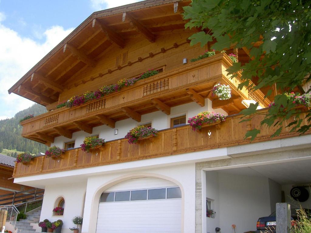 ein Gebäude mit einem Balkon mit Topfpflanzen darauf in der Unterkunft Knollnwies in Alpbach