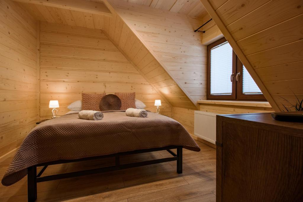 Un dormitorio con una cama en una casa de madera. en Apartamenty na Polnej, en Leśnica