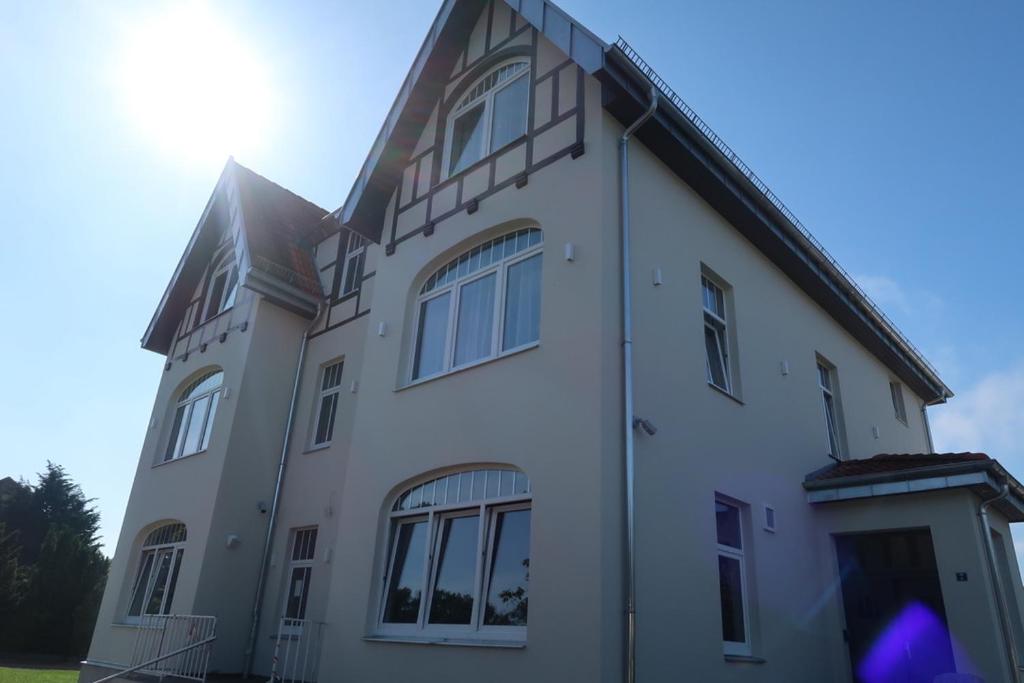 ein großes weißes Gebäude mit Fenstern auf dem Dach in der Unterkunft Lodge Boutique Hotel Kühlungsborn in Kühlungsborn
