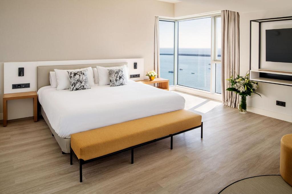 a bedroom with a large bed and a large window at Arrecife Gran Hotel & Spa in Arrecife