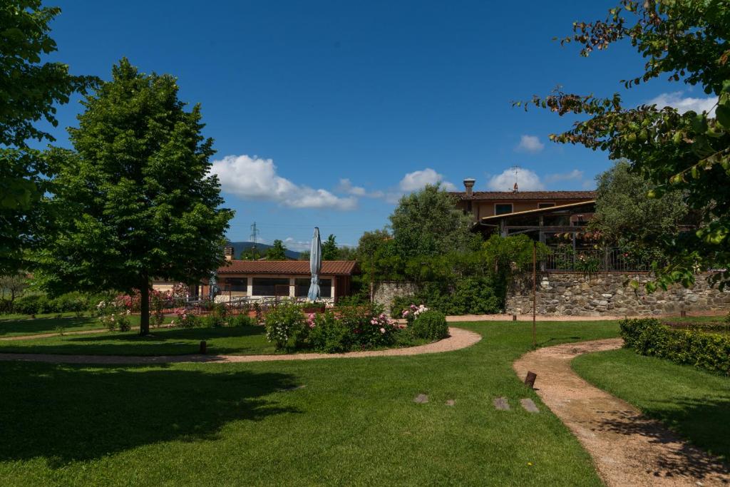 un jardín con una casa en el fondo en Locanda LA VALLE, en Castelnuovo Magra