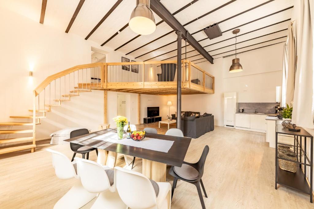 a dining room and kitchen with a wooden table and white chairs at Braviscasa - Ferienresidenz Kenzingen Europa Park in Kenzingen