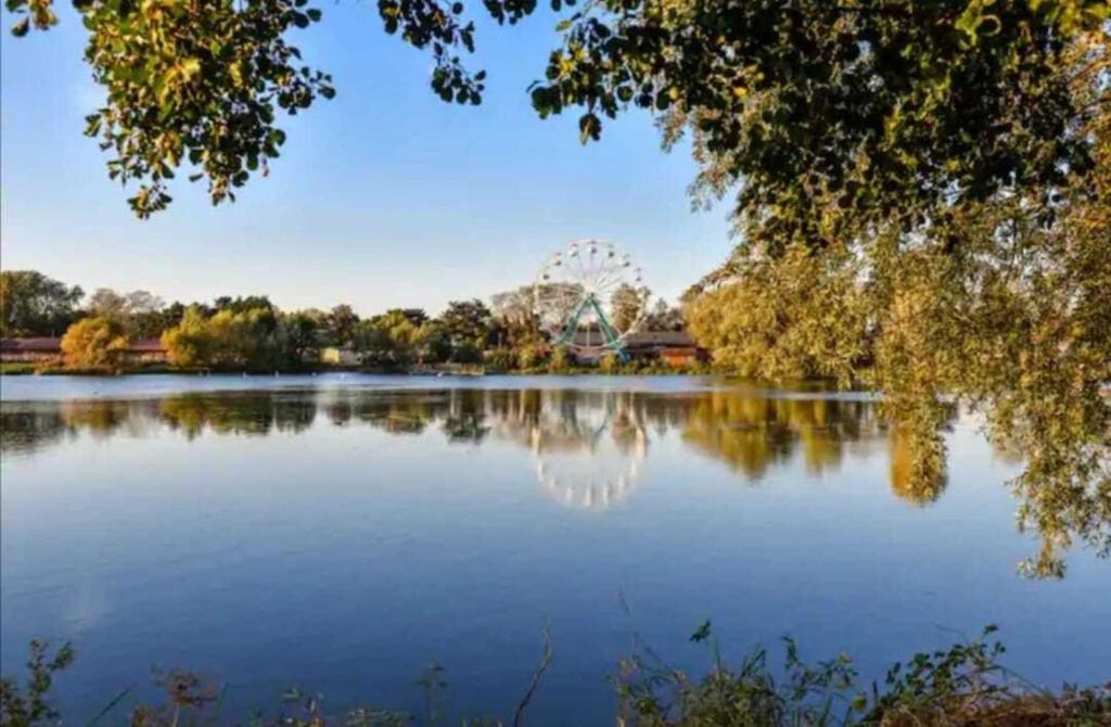 a view of a lake with a ferris wheel in the background at 2-Bed Caravan at Billing Aquadrome Northampton in Northampton