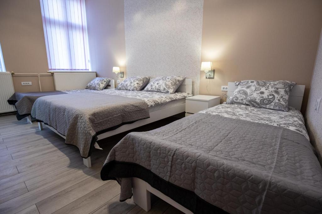 Habitación con 3 camas en una habitación en Apartments Borovo, en Subotica