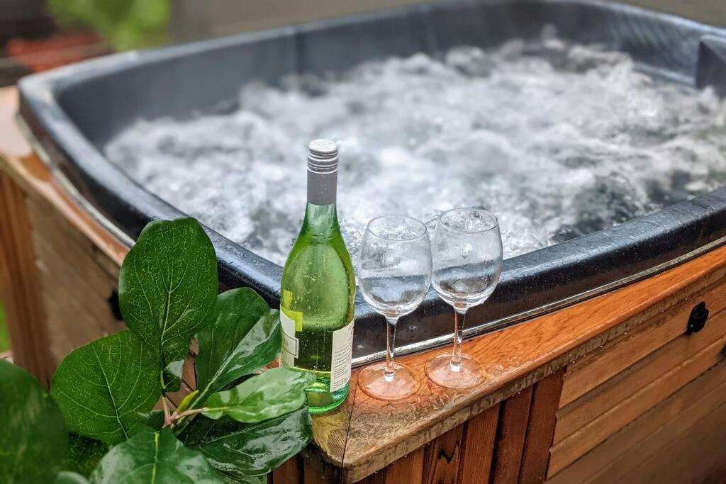 - Uma garrafa de champanhe e 2 copos de vinho numa banheira de hidromassagem; em Lux Central 3BR - outdoor spa em Albury