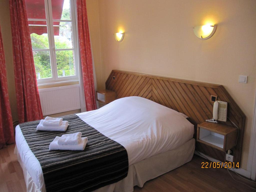 a bedroom with a bed with two towels on it at La Taverne des Deux Augustins in Étretat