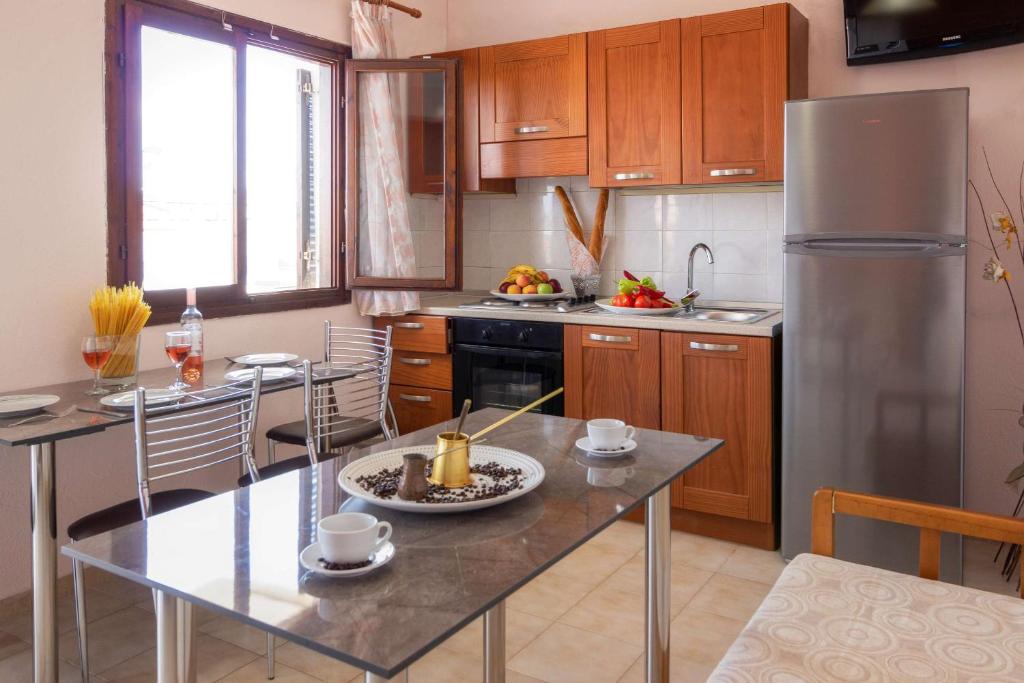 a kitchen with a stainless steel refrigerator and a table at Maria Rooms in Polychrono