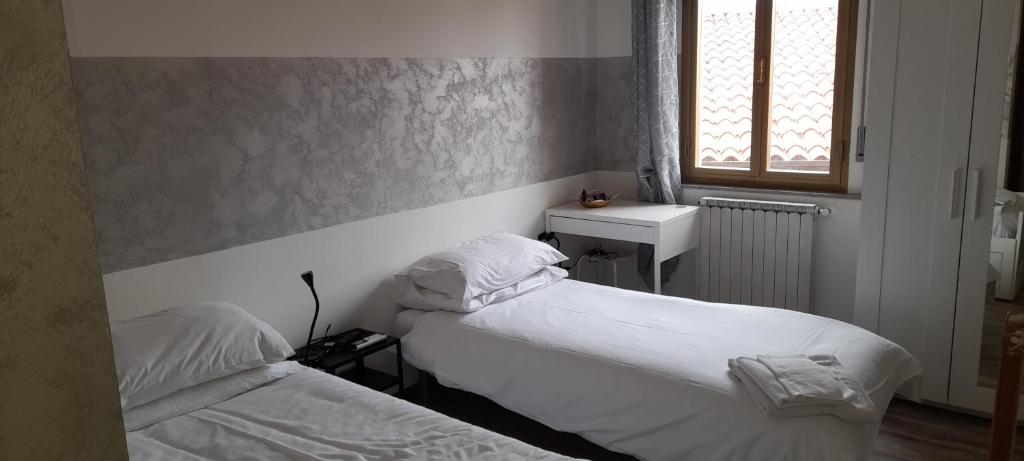 a bedroom with two beds and a sink and a window at affittacamere Silva in Trieste