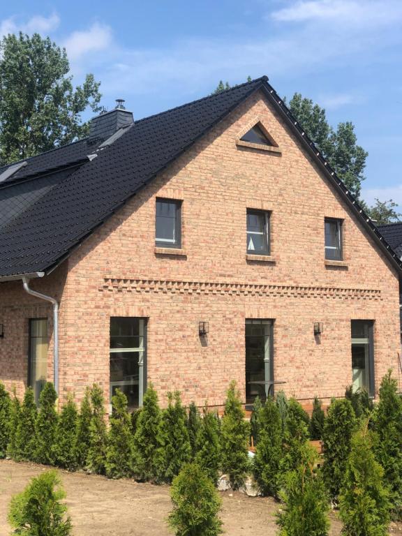 ceglany dom z czarnym dachem w obiekcie Ferienhaus Joline w mieście Middelhagen