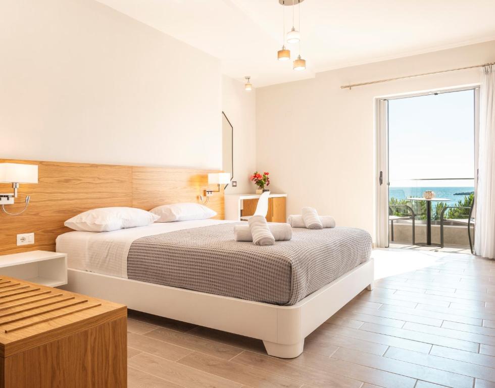 a bedroom with a large bed and a large window at Soñar en el mar in Himare