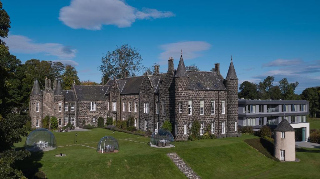 a large brick building with a clock tower on top of it at Meldrum House Hotel Golf And Country Estate in Oldmeldrum