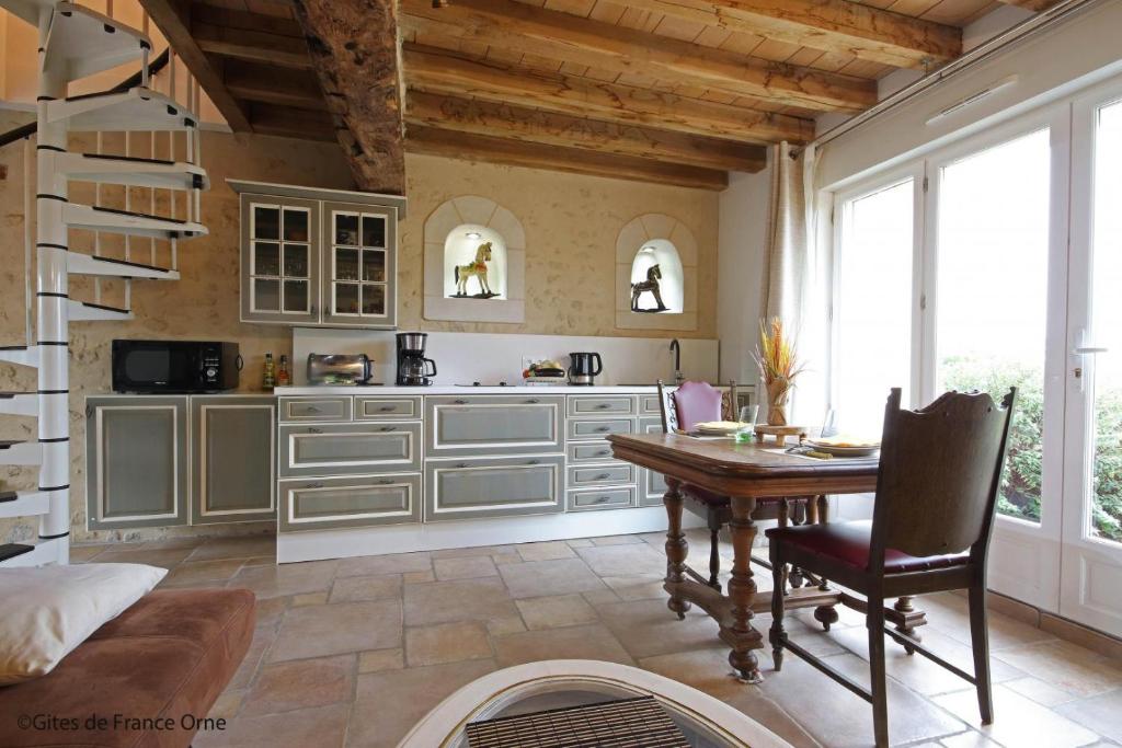 uma cozinha com uma mesa e uma sala de jantar em Gîtes dans le Perche, Le Forest em Colonard-Corubert