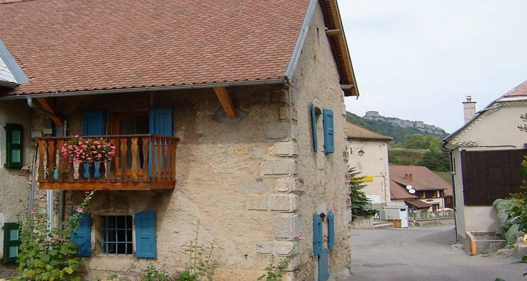 ein Gebäude mit einem Balkon mit Blumen darauf in der Unterkunft Les volets bleus in Gresse-en-Vercors