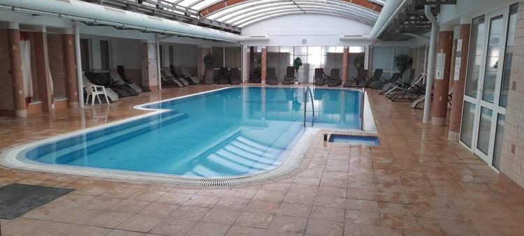 duży basen w dużym budynku w obiekcie VIOLA Wellness Apartman w Zalakaros