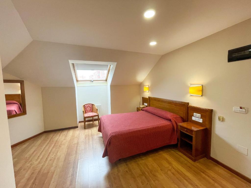 1 dormitorio con 1 cama roja y 1 silla en Arbeyal, en Gijón