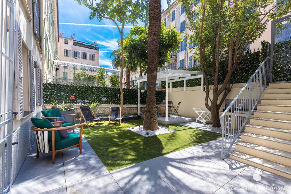 une cour avec une table, des chaises et un arbre dans l'établissement Luxury 3 Bdr Garden & Parking - Angels' Garden, à Nice