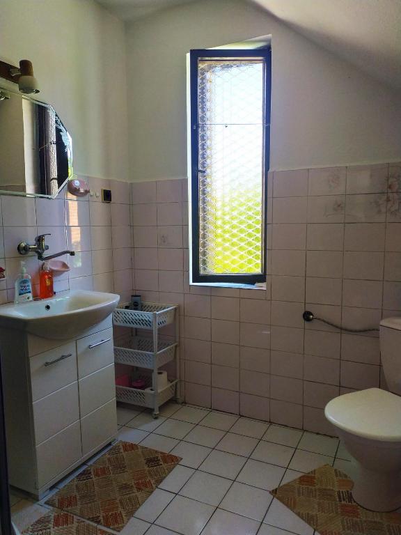 łazienka z umywalką, toaletą i oknem w obiekcie Penzion Renata w Trzeboniu