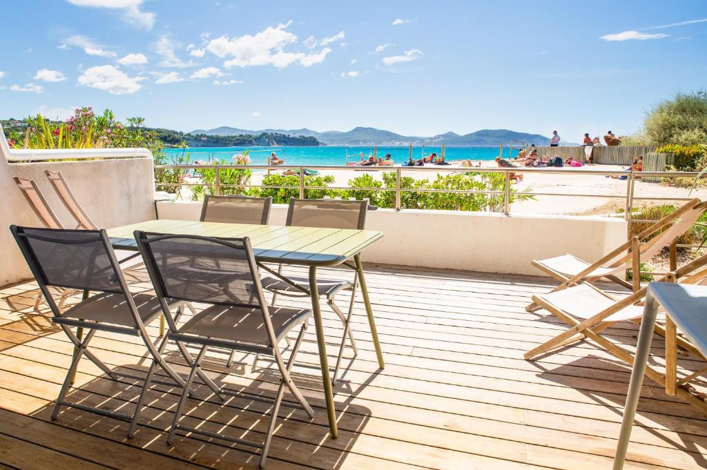 - une table et des chaises sur une terrasse avec vue sur la plage dans l'établissement plage st jean RESIDENCE LE GOLFE D AZUR, à La Ciotat