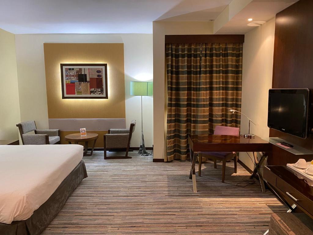 Uma TV ou centro de entretenimento em Phoenix Plaza Hotel Apartments