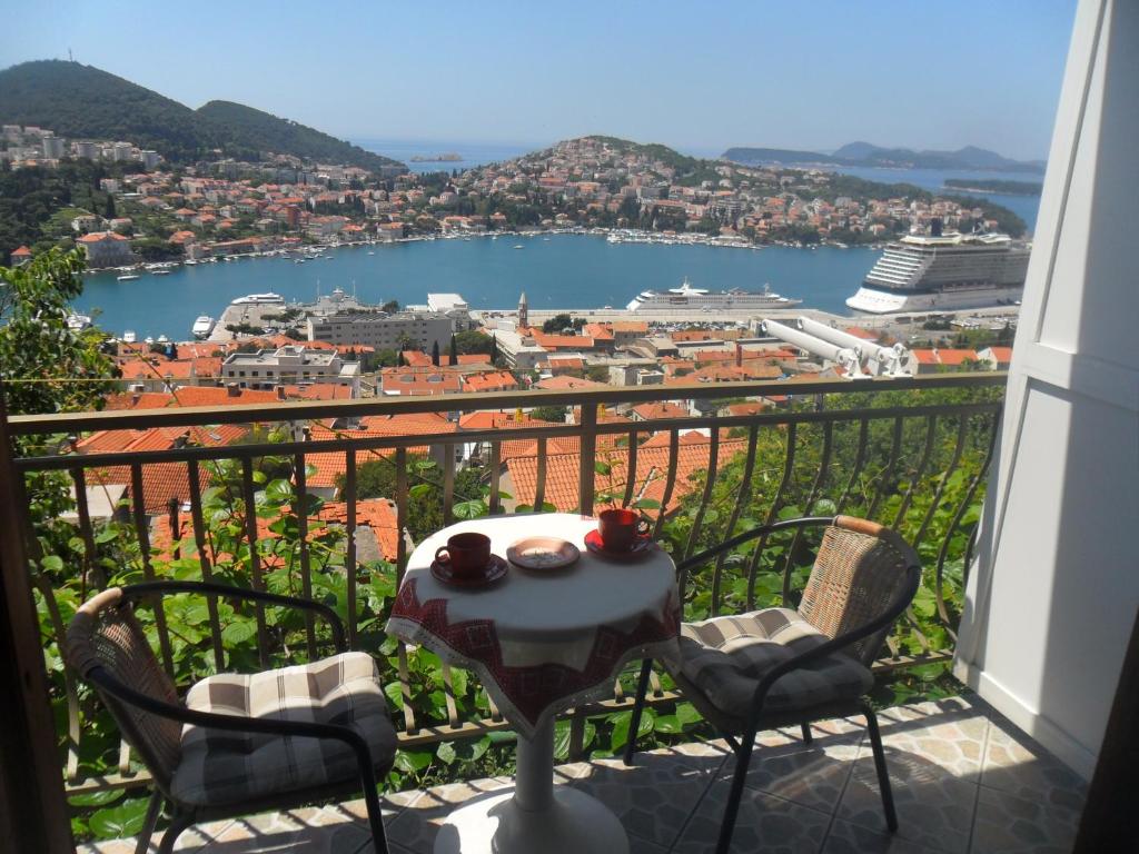 a table and chairs on a balcony with a view at Pansion Panorama Dubrovnik in Dubrovnik