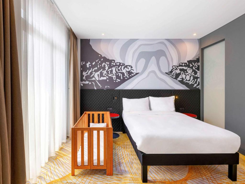 een slaapkamer met een bed en een schilderij aan de muur bij ibis Styles Istanbul Merter in Istanbul