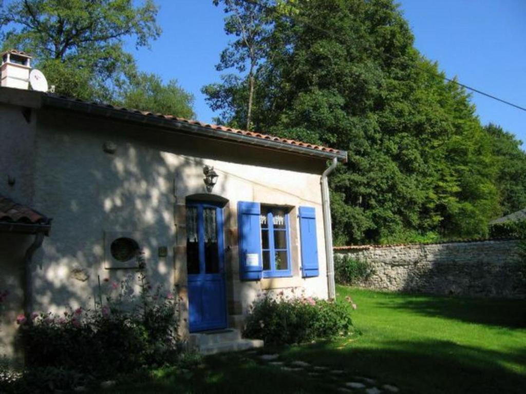 uma pequena casa com portas azuis e um quintal em Gîte Beausite-Deuxnouds Devant Beauzée, 3 pièces, 4 personnes - FR-1-585-4 