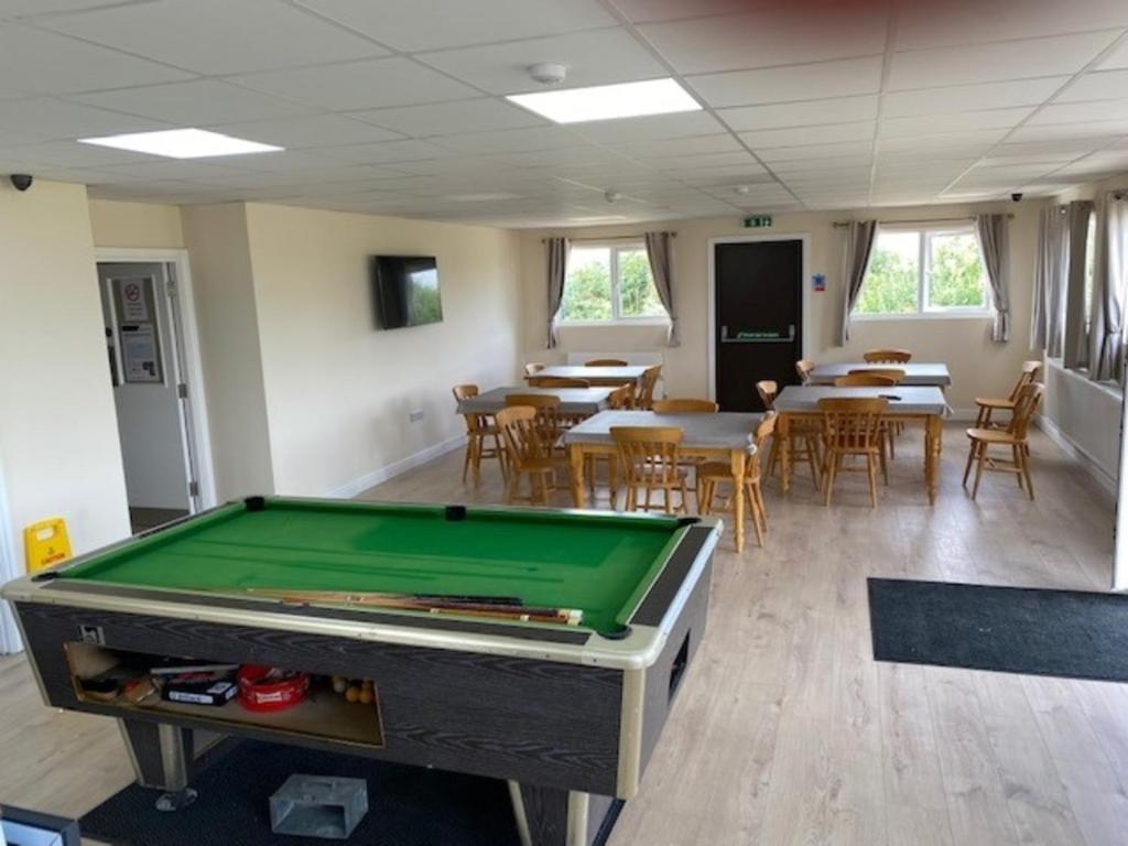 a pool table in a room with tables and chairs at Bucks accommodation in Aylesbury