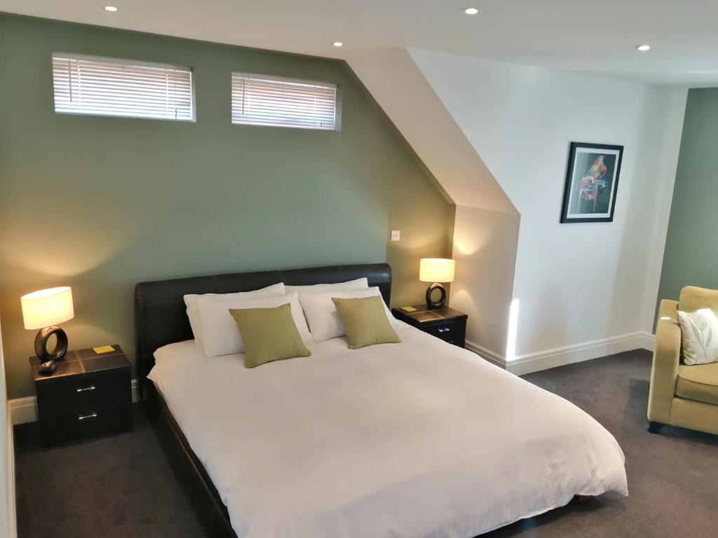 a bedroom with a large white bed and a chair at Lazy Days B&B in Broadstairs