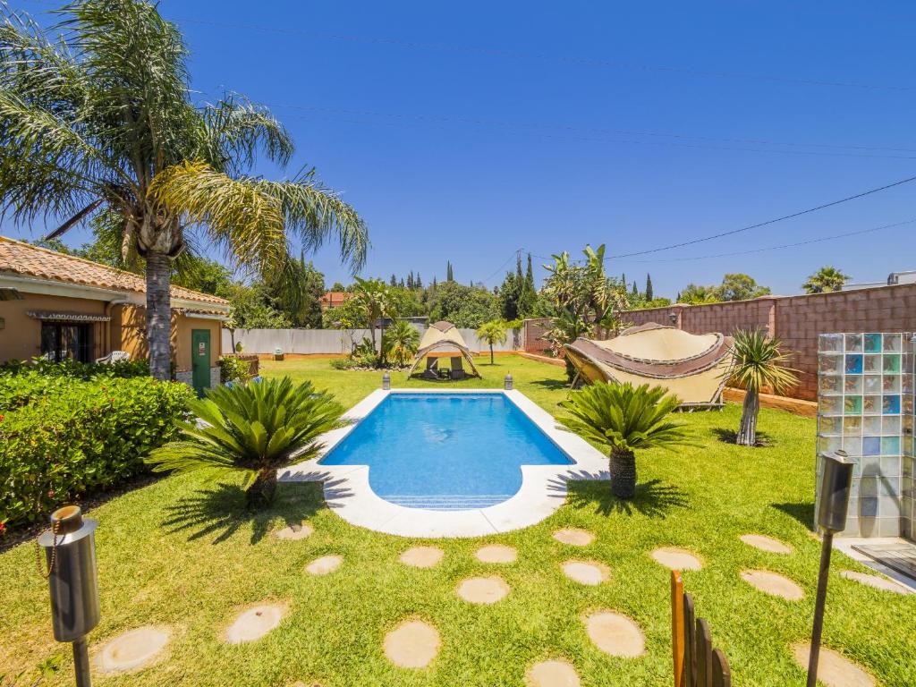 una piscina en un patio con una palmera en Cubo's Villa Lula, en Cártama