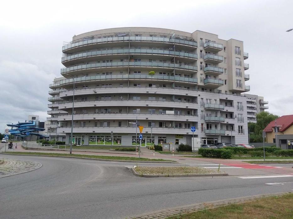 un gran edificio blanco al lado de una carretera en Apartament AQUAPARK en Reda