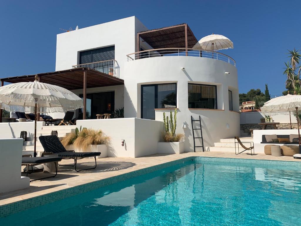 a villa with a swimming pool and a house at Casa Henrietta in Jávea