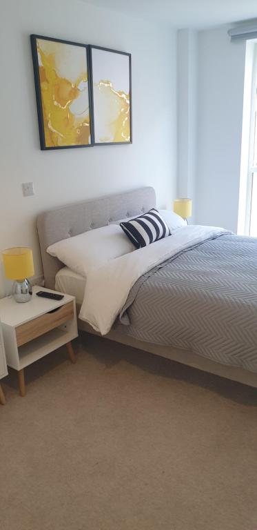 a bedroom with a bed and a table with a lamp at Quay Apartments Exchange Quay in Manchester