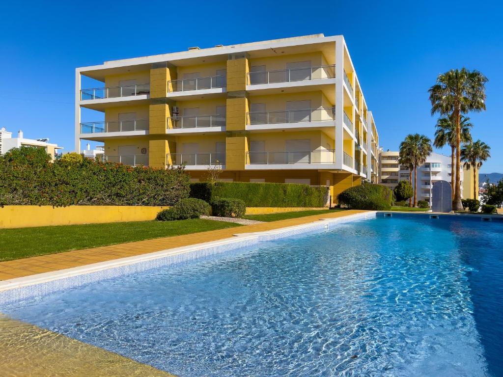 una piscina frente a un edificio de apartamentos en Apartamento Vila Arade, en Portimão