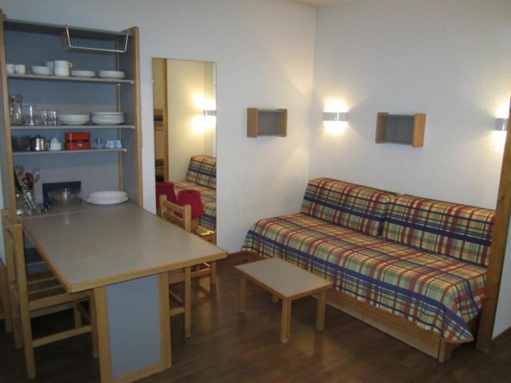 ein Zimmer mit einem Sofa und einem Tisch in einem Zimmer in der Unterkunft Studio Brides-les-Bains, 1 pièce, 4 personnes - FR-1-512-113 in Brides-les-Bains