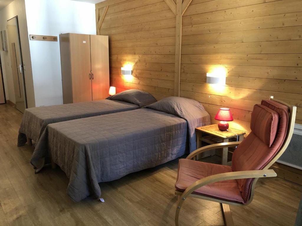 een slaapkamer met een bed, een stoel en een tafel bij Studio Brides-les-Bains, 1 pièce, 4 personnes - FR-1-512-6 in Brides-les-Bains