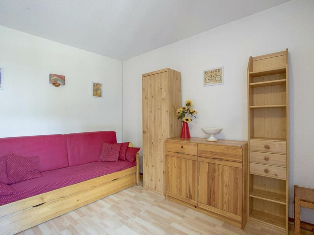 ein Wohnzimmer mit einem lila Sofa und einem Holzschrank in der Unterkunft Appartement Villard-de-Lans, 2 pièces, 4 personnes - FR-1-515-94 in Villard-de-Lans