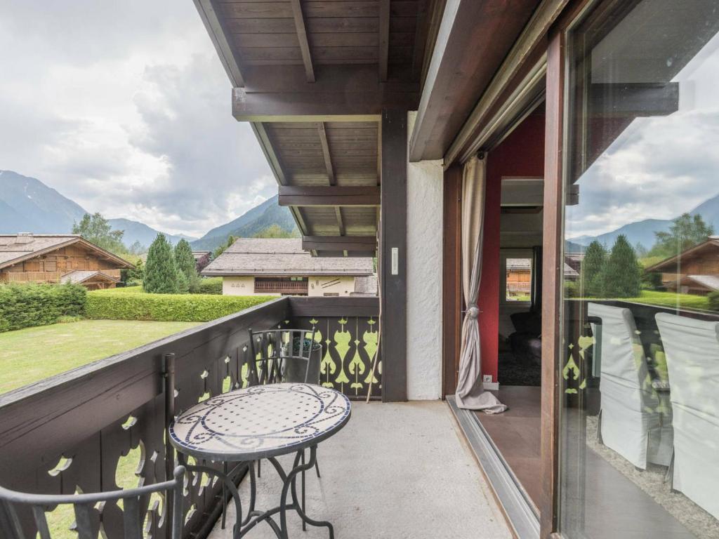 a patio with a table and chairs on a balcony at Appartement Chamonix-Mont-Blanc, 4 pièces, 6 personnes - FR-1-517-11 in Chamonix