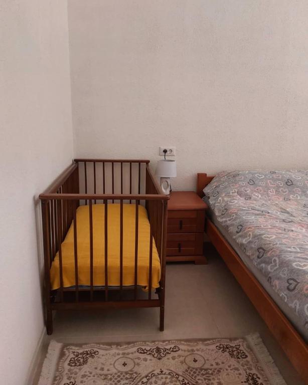 a small bedroom with a bed and a night stand at Petrovača in Žabljak