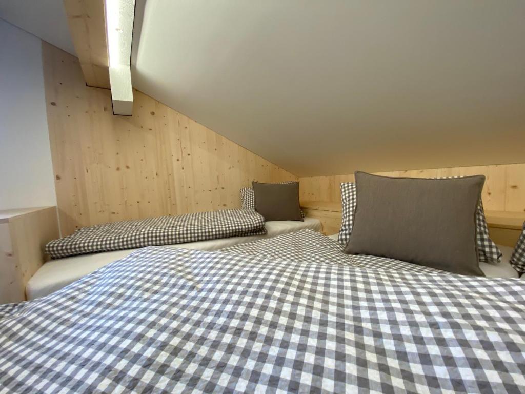 a bedroom with a bed with checkered sheets and pillows at Gasthaus Sulzfluh in Schruns