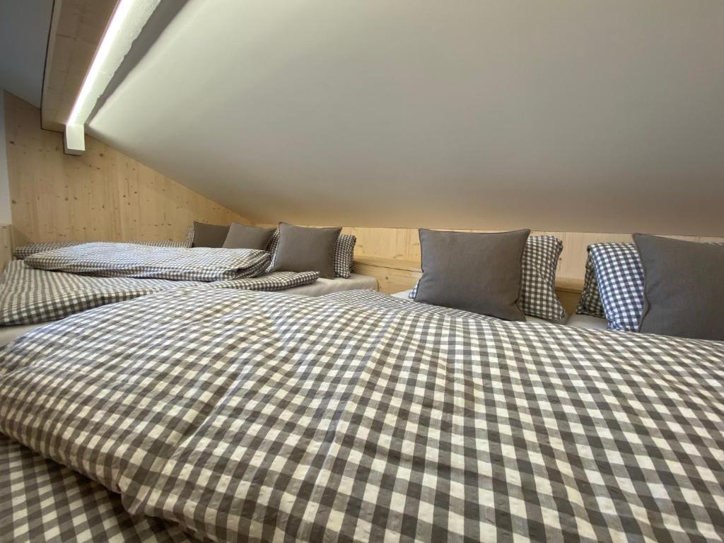 two beds in a room with checkered sheets at Gasthaus Sulzfluh in Schruns