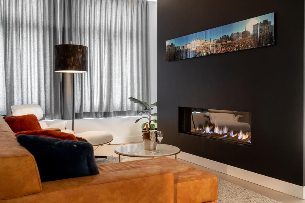 
a living room filled with furniture and a fire place at Bossche Suites No2 - Verwersstraat in Den Bosch
