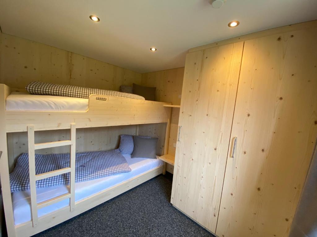 two bunk beds in a room with wooden walls at Gasthaus Sulzfluh in Schruns