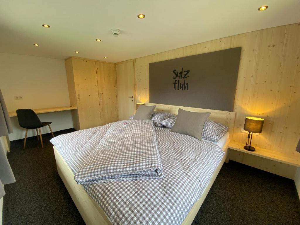 a bedroom with a bed with a checkered bedspread at Gasthaus Sulzfluh in Schruns