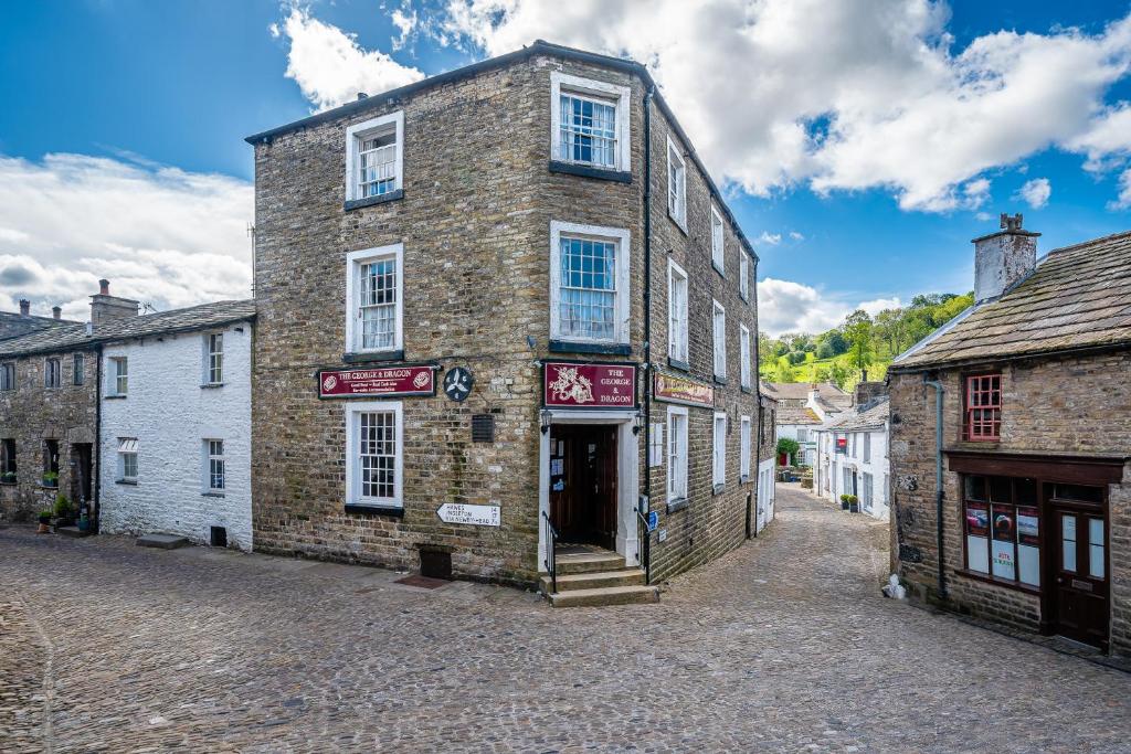 an old brick building on a cobblestone street at The George and Dragon in Dent